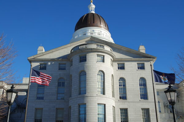 Maine Capitol building with American flag