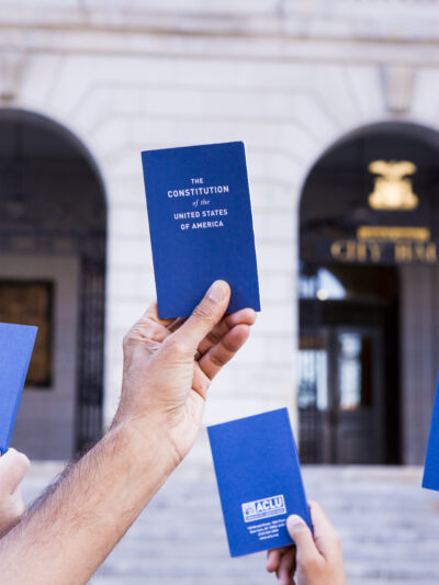 hands holding copies of the pocket Constitution