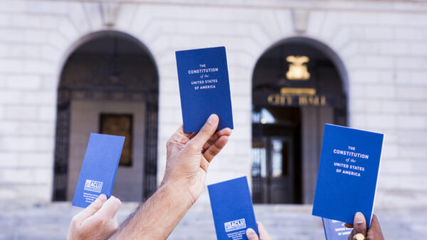 hands holding copies of the pocket Constitution