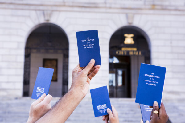 hands holding copies of the pocket Constitution