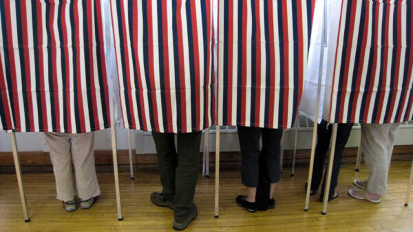 People standing in polling booths on election day