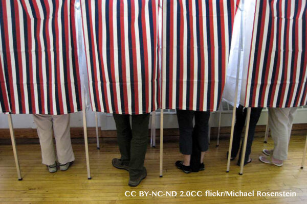 People standing in polling booths on election day