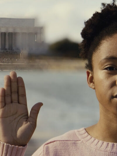 Little girl raising her right hand in front of Lincoln Memorial