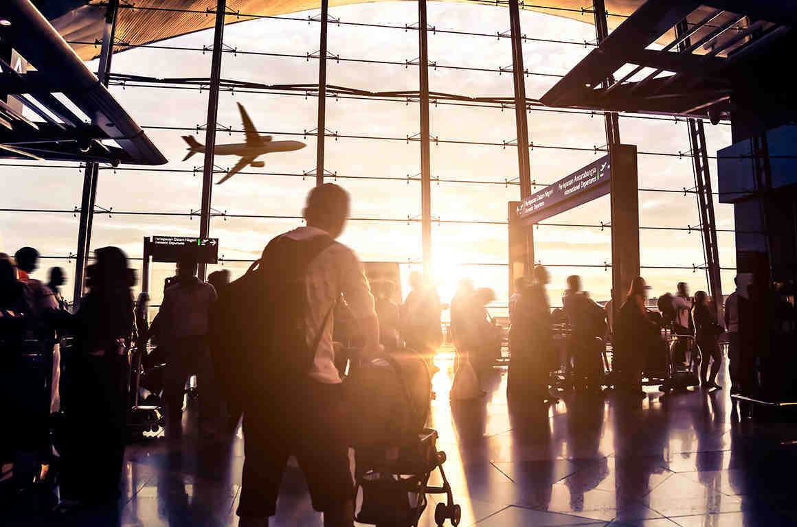 People moving through airport with luggage