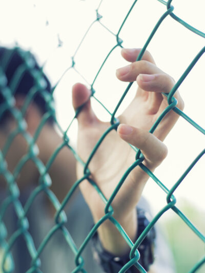 Child leaning on chainlink fence