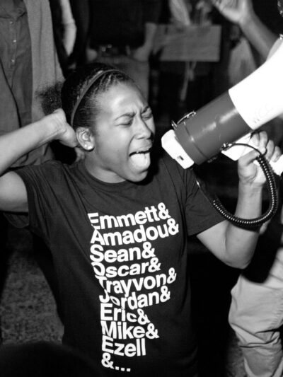 black and white film still from Whose Streets of activist with bullhorn