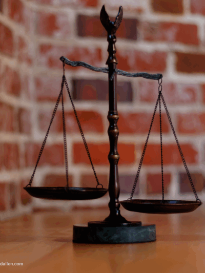 balanced scales of justice in front of brick wall