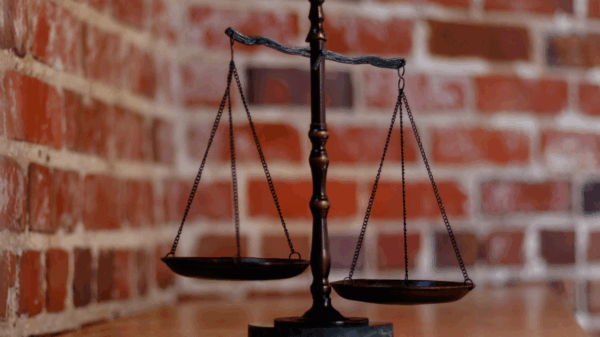 balanced scales of justice in front of brick wall