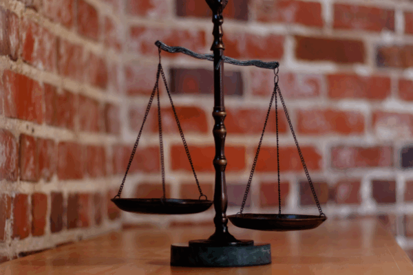 balanced scales of justice in front of brick wall