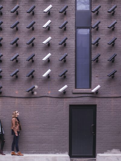 Two women looking up at a wall covered in security cameras