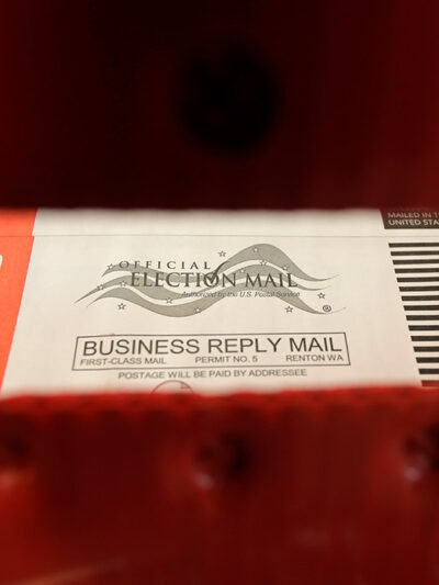 Absentee ballots are seen through a mailbin