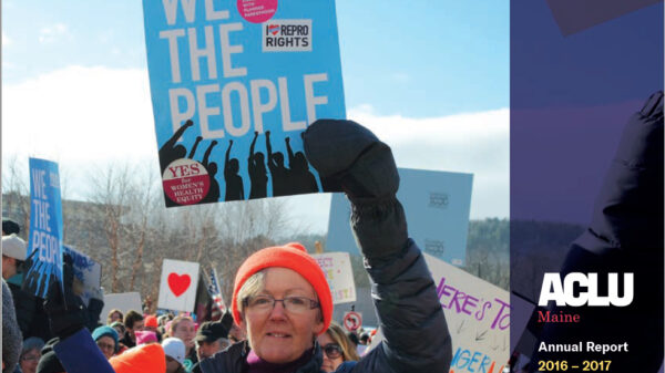 Annual Report cover with picture of woman holding blue sign that reads WE THE PEOPLE. White text in purple sidebar reads ACLU of Maine Annual Report 2016-2017