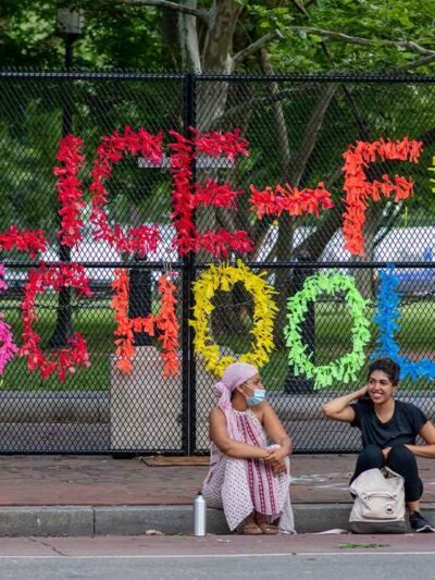Chain link fence reading "Police-Free Schools"