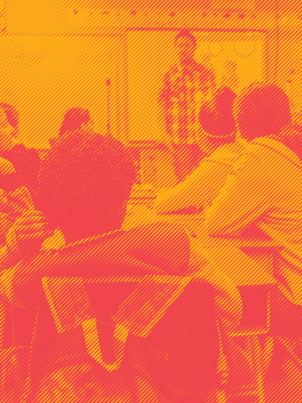 Students sitting at desks in classroom with teacher in front of class. Photo is in an orange and red duotone effect.