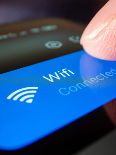 A finger touching a phonescreen to connect to wifi.