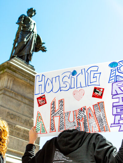 Person holding poster reading "housing is a human right."