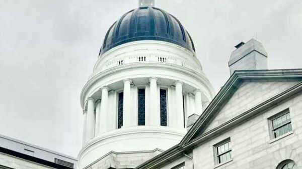 Rotunda of Maine Statehouse with cloudy skies behind