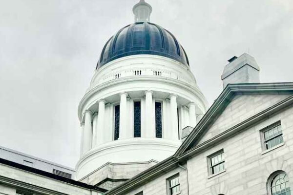 Rotunda of Maine Statehouse with cloudy skies behind