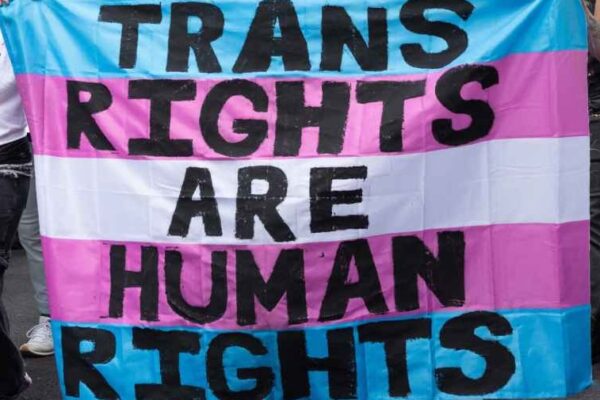 Trans Rights, speakers, protesters, and supporters denounce the Trump Administration's persistent attacks on the transgender community. by carrying a huge sign reading" TRANS RIGHTS ARE HUMAN RIGHTS".