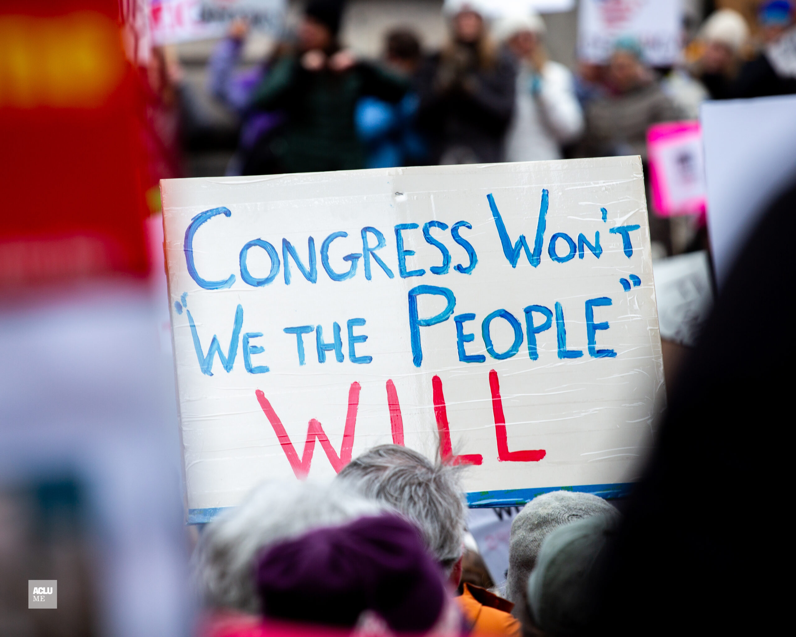 Person holding protest sign that says