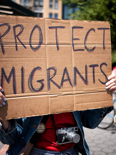A demonstrator holding a sign that says "Protect Immigrants."