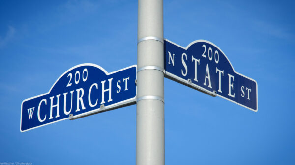 Two street signs at an intersection on a pole reading Church St on one and State St on the other.