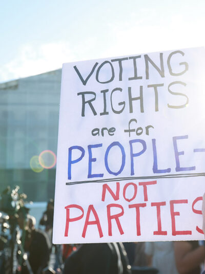 An individuals holding a sign saying "Voting Rights Are For People Not Parties," outside of the U.S. Supreme Court ahead of arguments in the Voting Rights case Callais v. Landry.