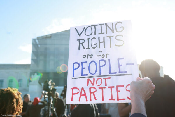 An individuals holding a sign saying "Voting Rights Are For People Not Parties," outside of the U.S. Supreme Court ahead of arguments in the Voting Rights case Callais v. Landry.