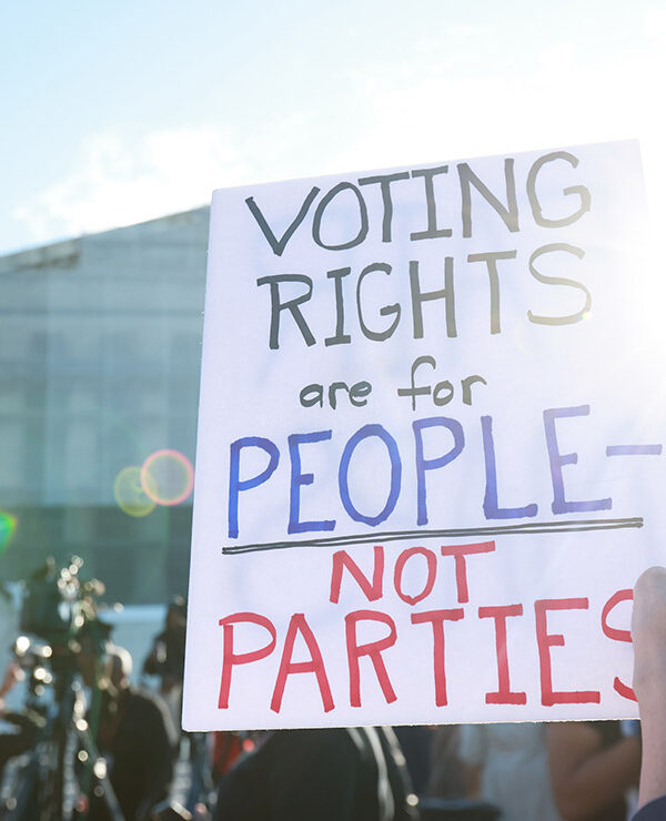 An individuals holding a sign saying "Voting Rights Are For People Not Parties," outside of the U.S. Supreme Court ahead of arguments in the Voting Rights case Callais v. Landry.