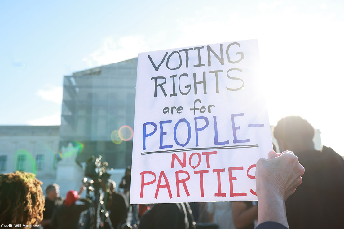 An individuals holding a sign saying "Voting Rights Are For People Not Parties," outside of the U.S. Supreme Court ahead of arguments in the Voting Rights case Callais v. Landry.