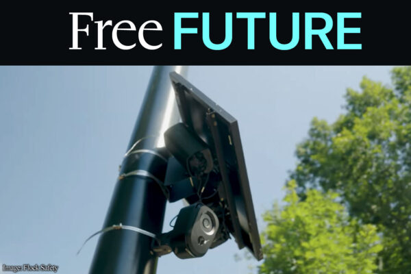 A license plate reader against sky and trees