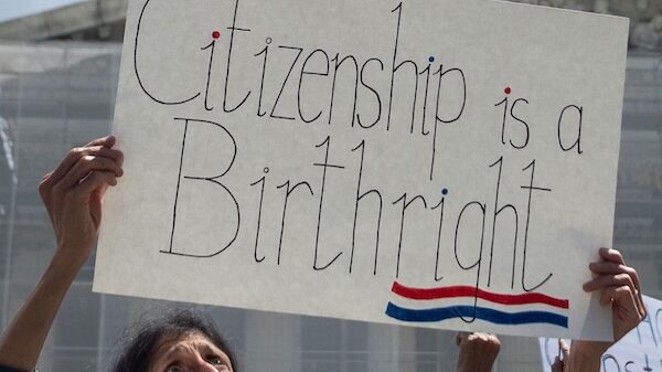 woman holding "citizenship is a birthright" sign