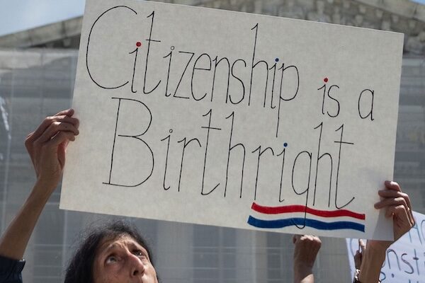 woman holding "citizenship is a birthright" sign