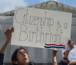 woman holding "citizenship is a birthright" sign