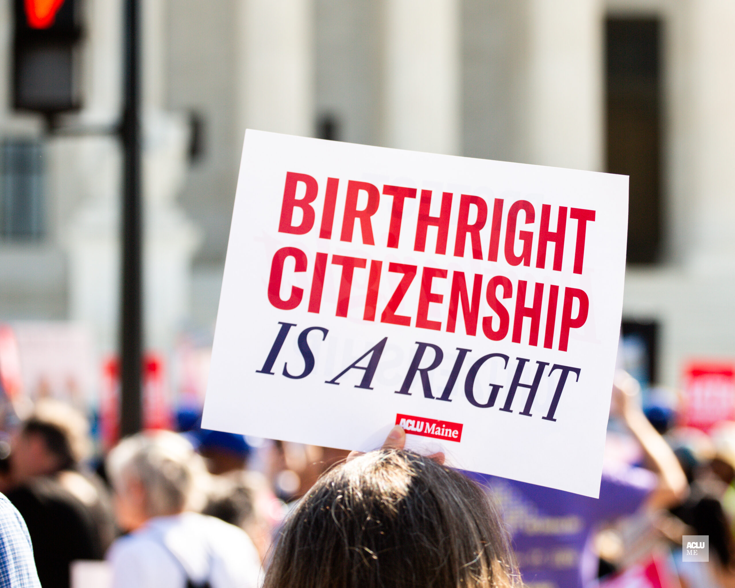 Person holding sign reading: Birthright citizenship is a right