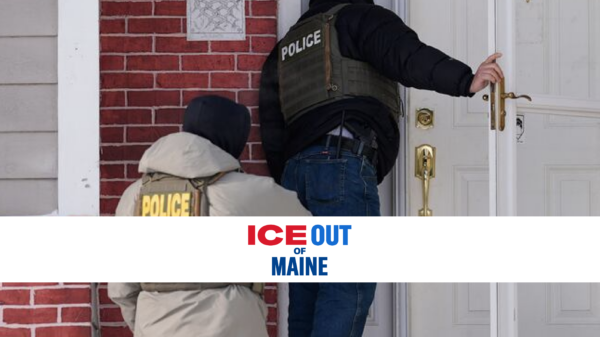 Law enforcement officers at the door of a brick home.