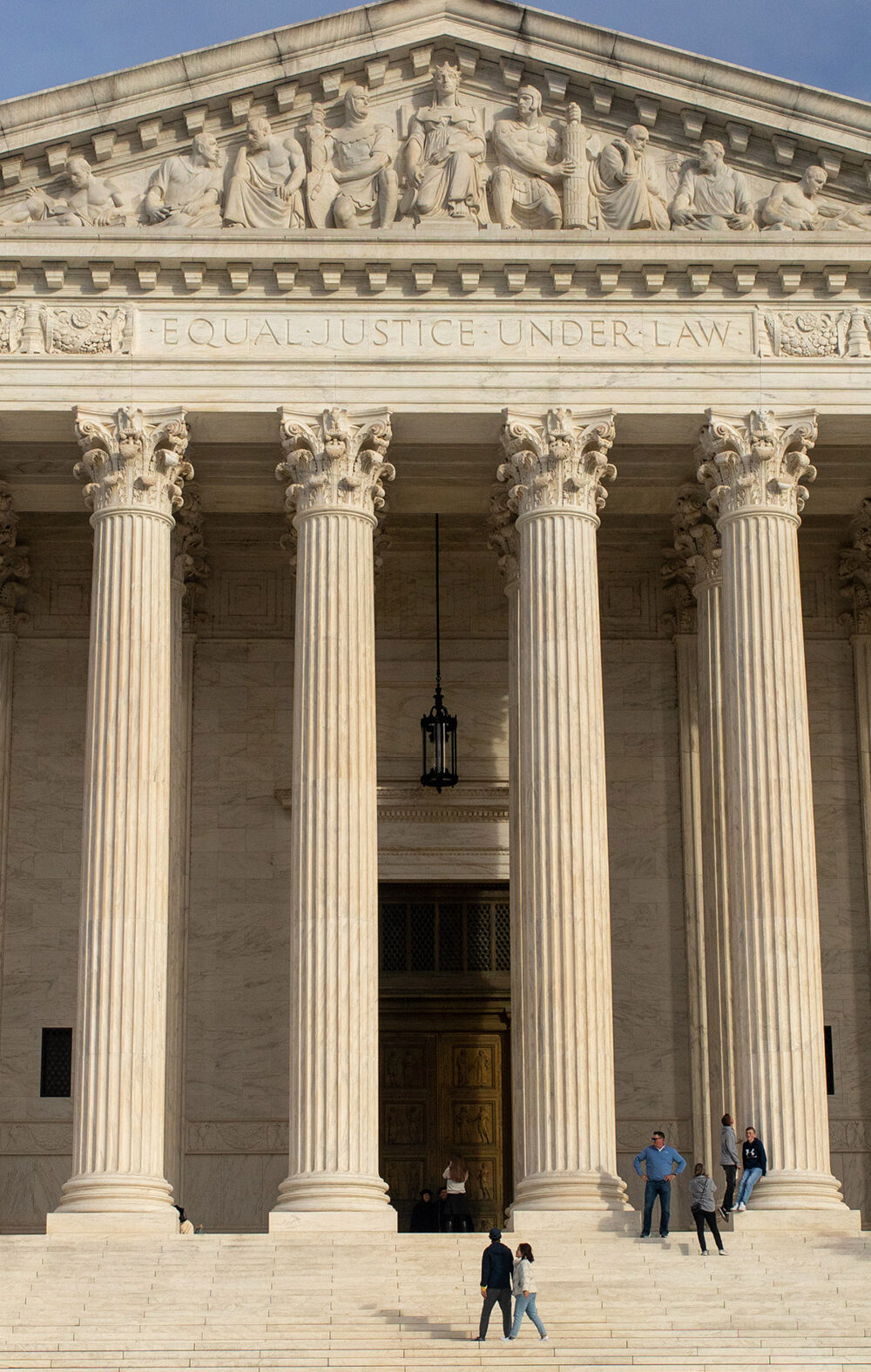 The facade of the Supreme Court of the United States building against a blue sky,