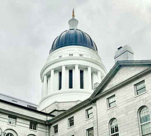 Rotunda of Maine Statehouse with cloudy skies behind