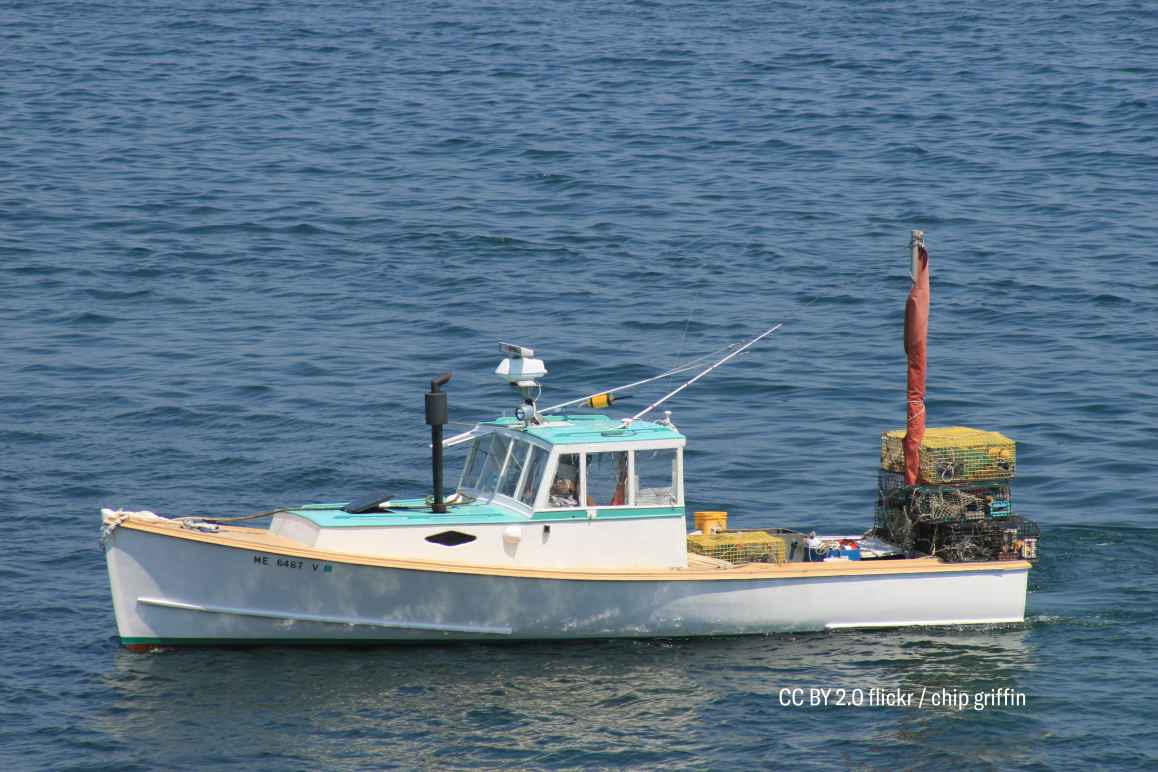 white lobster boat with traps in Maine harbor