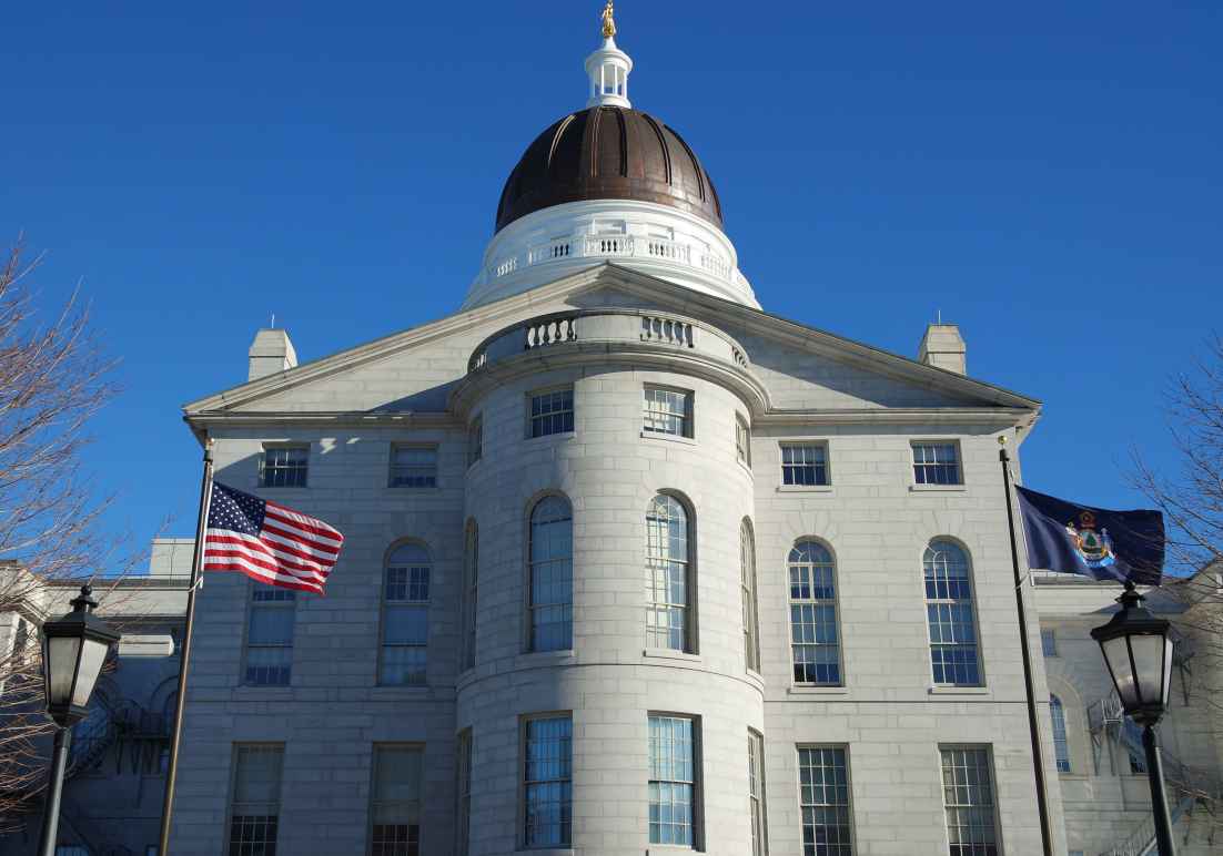 Maine Capitol building with American flag