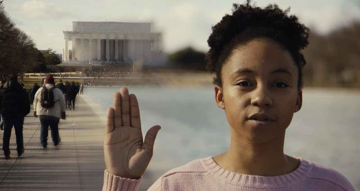 Little girl raising her right hand in front of Lincoln Memorial 
