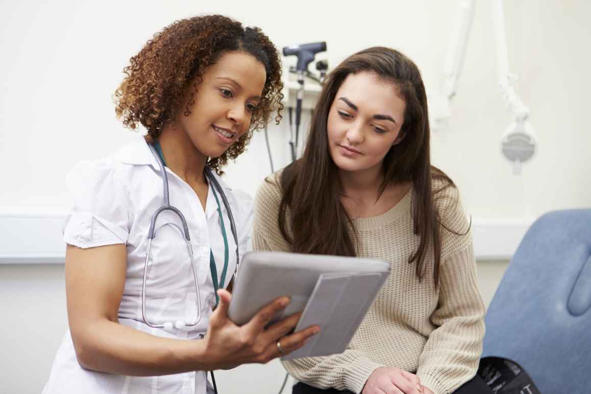 Nurse with stethoscope consulting with a patient in a medical office