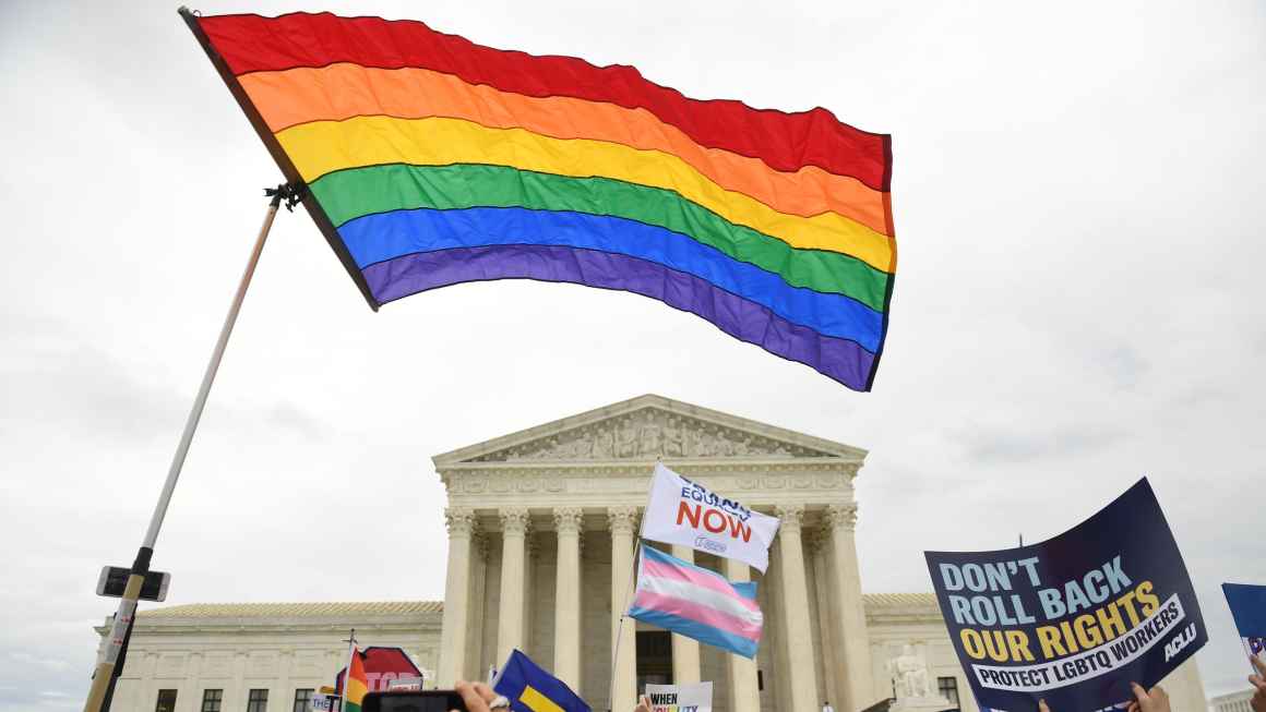 Pride flag flying in front of the US Supreme Court in foreground. In bottom right corner, ACLU poster reading "don't roll back our rights."