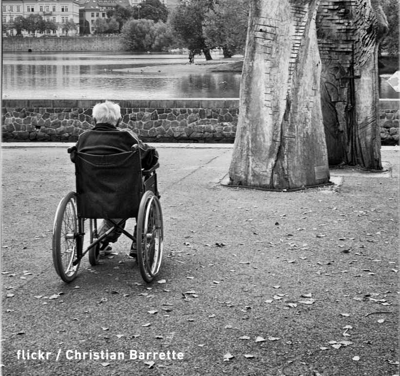 black and white photo of elderly man in wheelchair