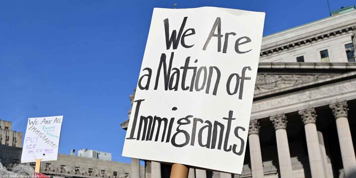 Two signs are held up during the May Day March In Manhattan, New York on May 1, 2025. The largest of the signs is in the foreground and reads"We Are a Nation of Immigrants," while the smaller in the background reads, " WE ARE ALL (EXCEPT NATIVE...