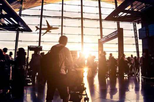 People moving through airport with luggage 