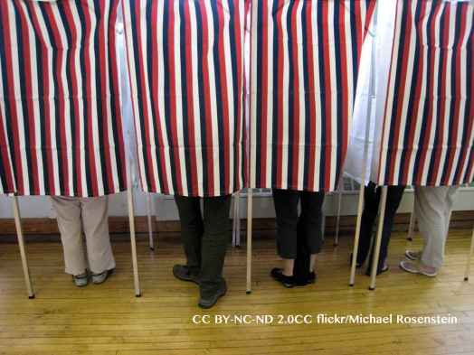 People standing in polling booths on election day