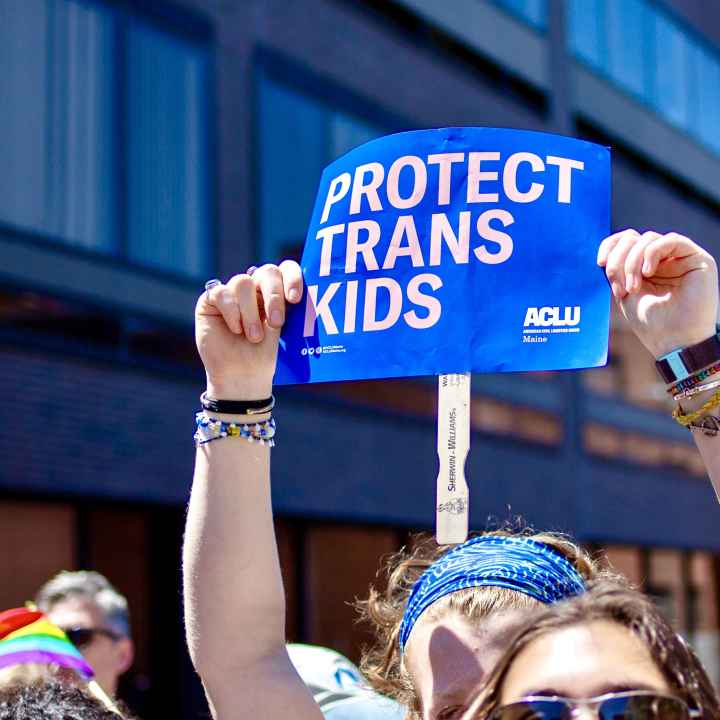 Protect Trans Kids Placard at 2024 Portland Pride Parade Person holding blue poster reading "protect trans kids" while marching in Portland Pride Parade, 2024.