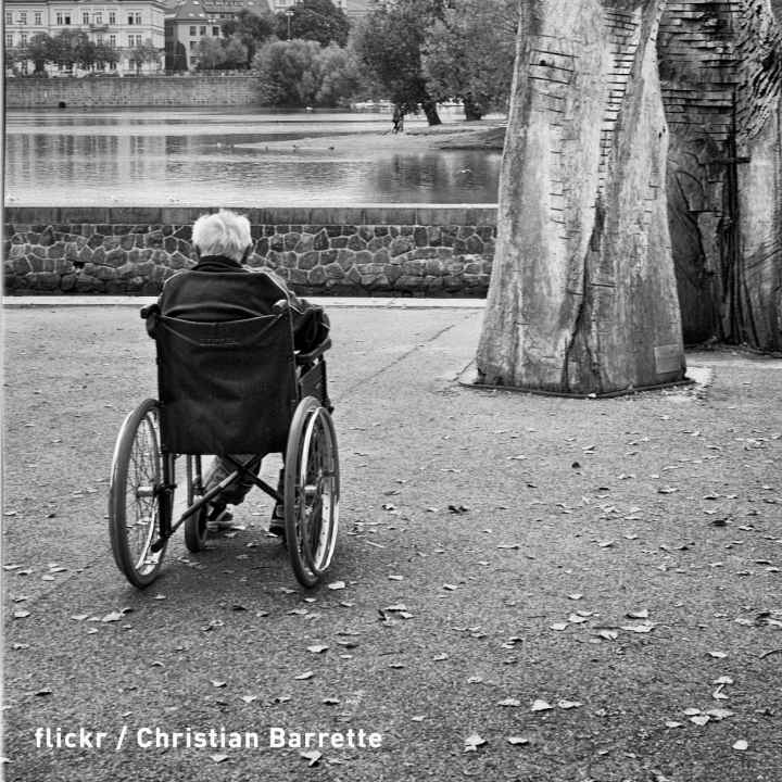 black and white photo of elderly man in wheelchair